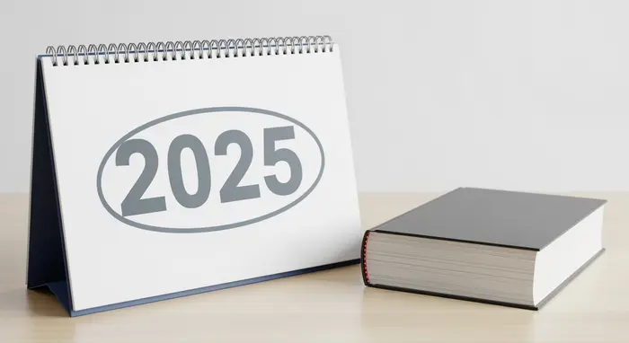 Symbolbild Reform: Kalenderblatt mit markiertem Jahr 2025 neben einem neutralen Gesetzbuch auf einem Schreibtisch; moderne, sachliche Darstellung ohne lesbare Details.
