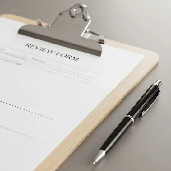 Übersichtlicher Bewertungsbogen auf Klemmbrett neben Stift, ohne lesbaren Text.