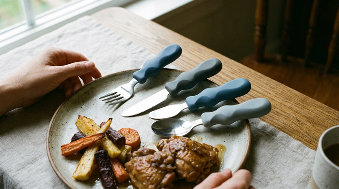 Besteck mit verdickten, ergonomischen Griffen auf einem Teller