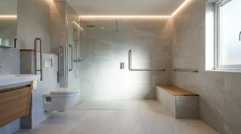 Modernes barrierefreies Badezimmer mit ebenerdiger Dusche und stabilen Haltegriffen