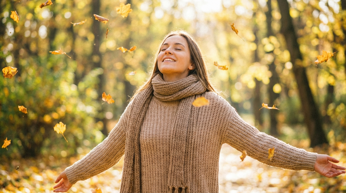 Junge Frau geht im Park spazieren, atmet tief durch (Selbstfürsorge)