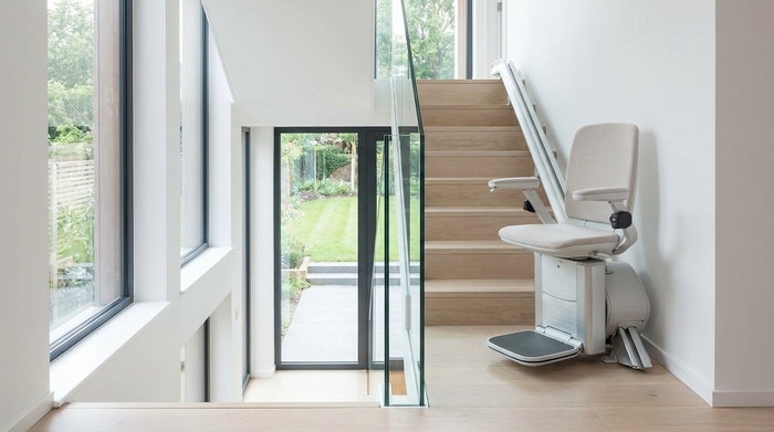 Moderner Treppenlift in einem hellen Treppenhaus, Sitz ist zur Seite gedreht
