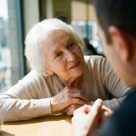 Seniorin hört im Gespräch aufmerksam zu