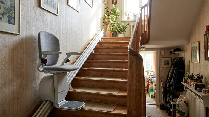 Treppenlift an einer geraden Holztreppe in einem Wohnhaus