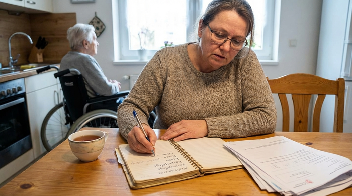 Angehörige notiert Pflegeaufwand in einem Notizbuch
