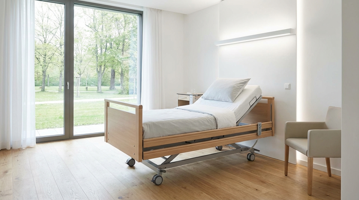Modernes, helles Krankenhauszimmer mit einem verstellbaren Pflegebett in Seitenansicht