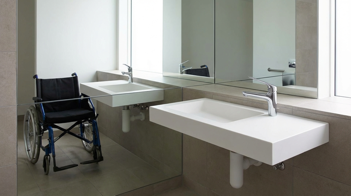 Flacher, unterfahrbarer Waschtisch mit einem leicht bedienbaren Einhebelmischer und großem Spiegel.