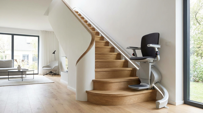 Moderner Treppenlift an einer geschwungenen Holztreppe