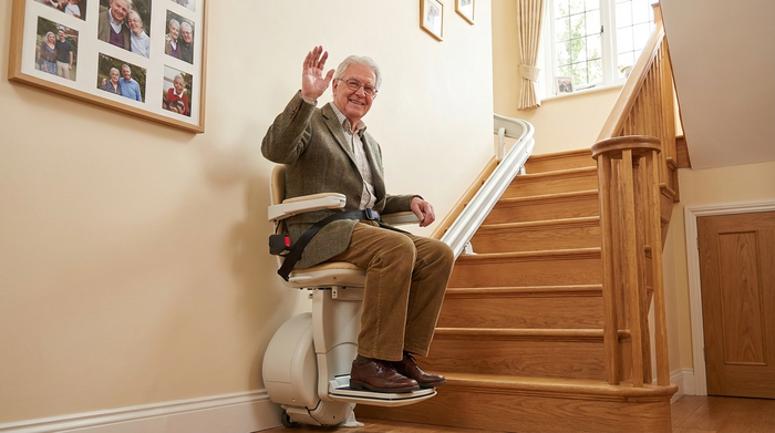 Senior fährt sicher mit einem Treppenlift ins obere Stockwerk