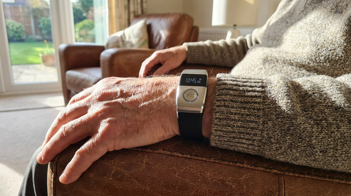 Modernes Hausnotruf-Armband am Handgelenk eines Seniors