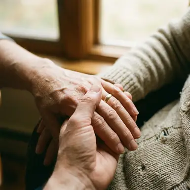 Zwei Hände halten sich sanft und beruhigend