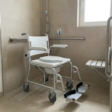 Praktischer Duschrollstuhl in einer bodengleichen, barrierefreien Dusche.