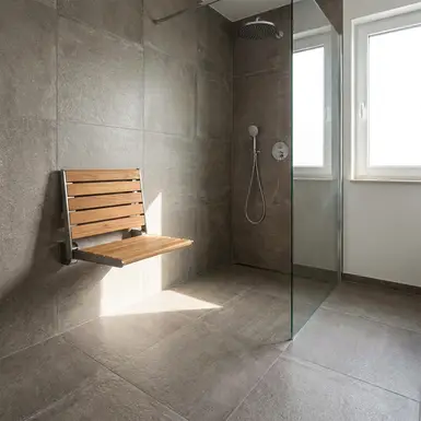 Moderne, bodengleiche Dusche mit rutschfesten Fliesen und einem stabilen Duschklappsitz