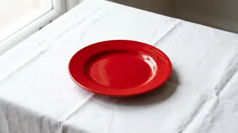 Roter Teller auf einer weißen Tischdecke zur besseren visuellen Wahrnehmung