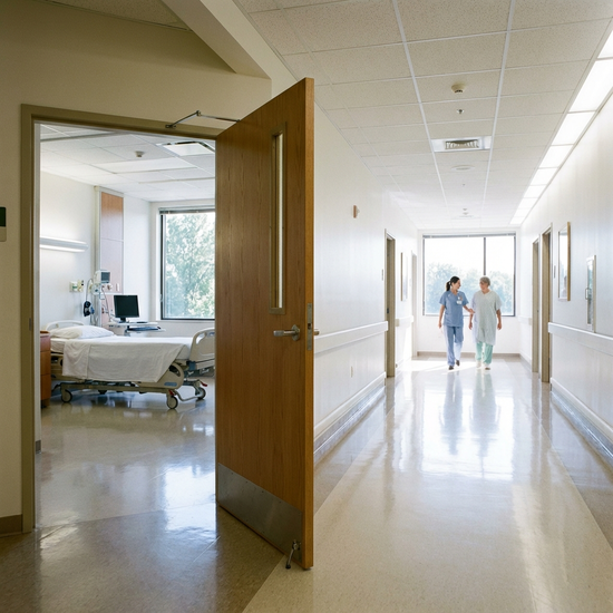 Krankenhausflur mit geöffneter Zimmertür, hell und sauber