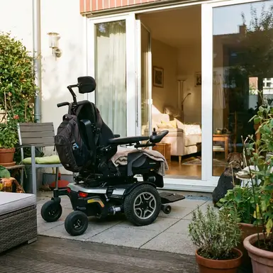 Elektrischer Rollstuhl steht bereit vor einer geöffneten Terrassentür