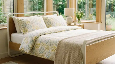 Frisch bezogenes, faltenfreies Pflegebett mit hellen, freundlichen Bezügen