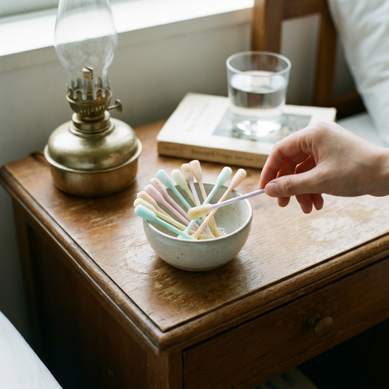 Weiche Schaumstoffstäbchen zur Mundpflege in einer kleinen Schale auf einem Nachttisch