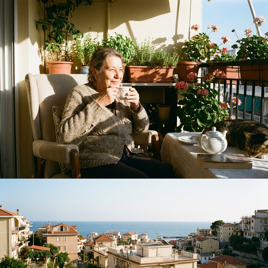 Eine ältere Frau trinkt entspannt eine Tasse Tee auf einem sonnigen Balkon