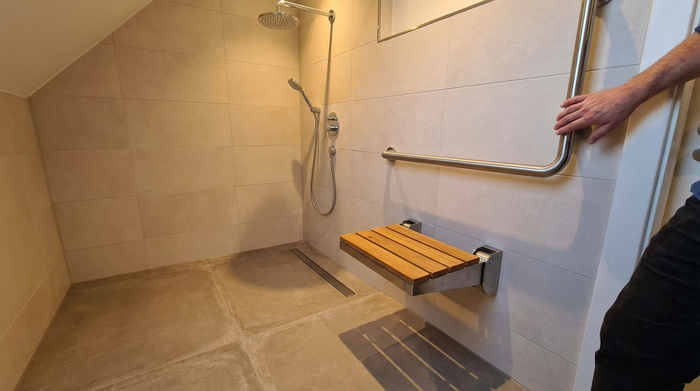 Bodengleiche Dusche mit Haltegriff und sicherem Klappsitz an der Wand