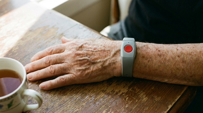 Hausnotruf-Armband am Handgelenk einer älteren Person