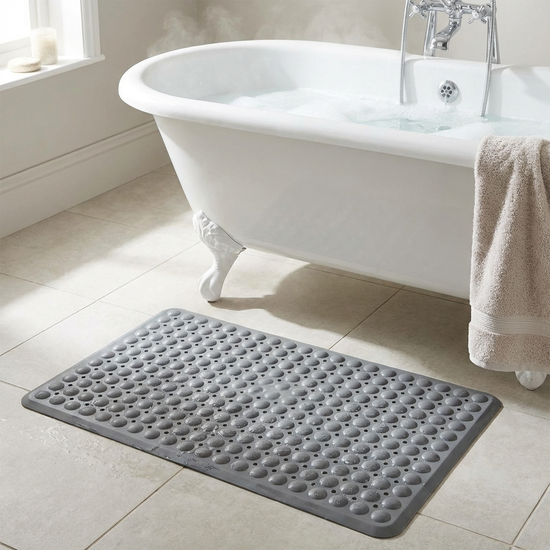 Gummierte, rutschfeste Badematte vor einer weißen Badewanne