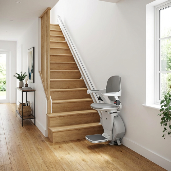Moderner, gerader Sitztreppenlift montiert auf einer geradlinigen Holztreppe in einem gepflegten Flur