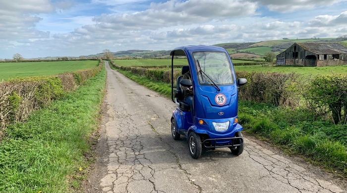 Blaues 15 km/h Elektromobil auf einem asphaltierten Feldweg