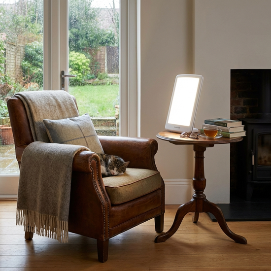 Tageslichtlampe auf einem Beistelltisch neben einem gemütlichen Lesesessel