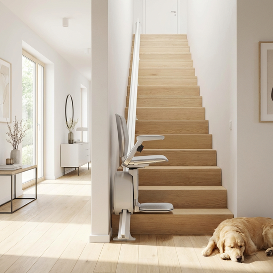 Moderner Treppenlift an einer hellen Holztreppe im Einfamilienhaus