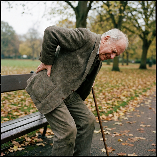 Senior hält sich schmerzverzerrt den Rücken