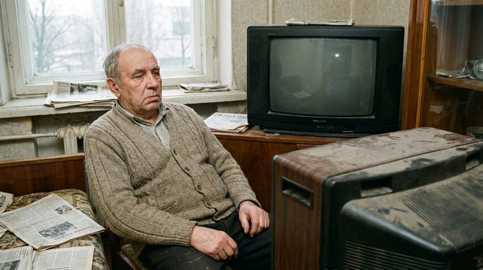 Senior starrt apathisch auf einen leeren Fernseher