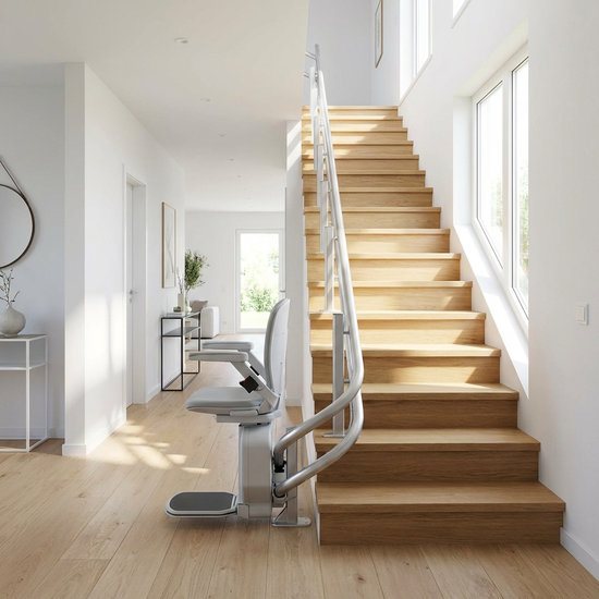 Moderner Sitzlift auf einer geraden Holztreppe im hellen Flur eines Einfamilienhauses