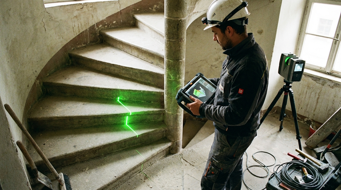 Techniker vermisst eine Treppe mit einem digitalen Messgerät