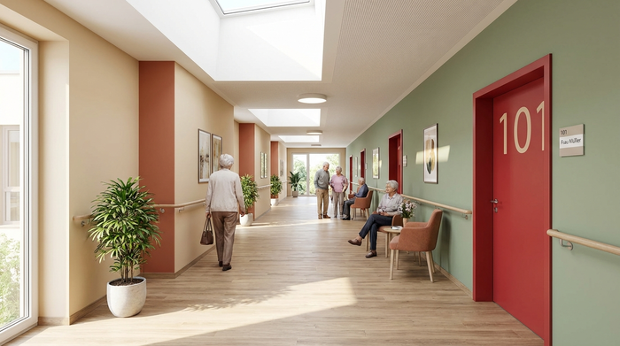 Ein heller, übersichtlicher Flur in einer modernen Pflegeeinrichtung, gestaltet als sogenannter Rundweg ohne Sackgassen. Warme, beruhigende Wandfarben und eine farblich hervorgehobene rote Zimmertür erleichtern die Orientierung für Senioren.