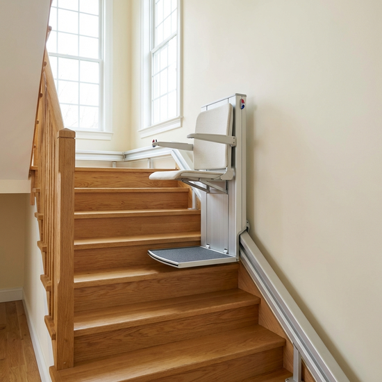 Ein moderner, unauffälliger Treppenlift an einer Holztreppe in einem gepflegten Einfamilienhaus. Helle Wände, sichere und saubere Umgebung.