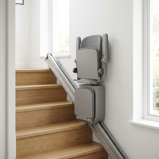 Ein moderner, unauffälliger Treppenlift in einem gepflegten, hellen Treppenhaus eines Einfamilienhauses. Der Sitz ist hochgeklappt und platzsparend.