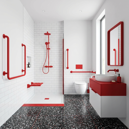 Ein helles Badezimmer mit starken Farbkontrasten. Rote Haltegriffe an den weißen Wänden helfen bei der Orientierung. Modern, sauber und barrierefrei.