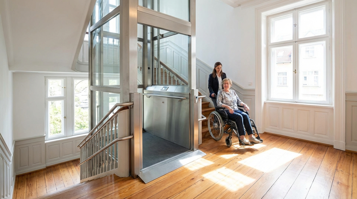 Ein moderner, unauffälliger Treppenlift in einem gepflegten, hellen Treppenhaus eines Altbaus. Fokus auf Barrierefreiheit und Sicherheit, realistische Szene ohne Text.