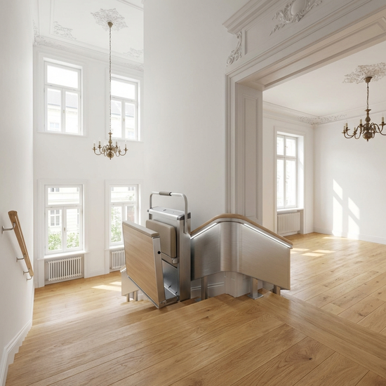 Ein moderner Treppenlift gleitet sanft eine helle Holztreppe hinab, sauberes und gepflegtes Treppenhaus in einem klassischen Altbau.
