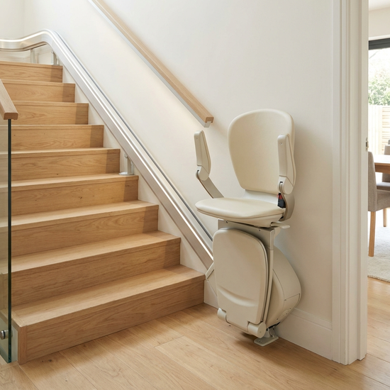 Ein eleganter, elektrischer Treppenlift in einem gepflegten Einfamilienhaus. Die Schiene verläuft entlang einer hellen Holztreppe, modernes, unauffälliges und sicheres Design.