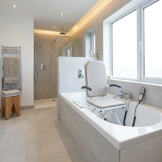 Ein komfortabler Badewannenlift ist sicher in einer sauberen, weißen Badewanne installiert. Das Badezimmer ist modern, gut beleuchtet und mit rutschfesten Fliesen ausgestattet.