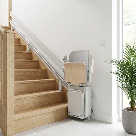 Ein moderner, unauffälliger Treppenlift in einem gepflegten Einfamilienhaus. Helle Holztreppe, sichere und saubere Umgebung ohne Text.