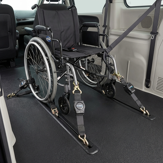 Ein detaillierter Blick auf ein professionelles Gurtsystem im Fahrzeugboden, das einen Rollstuhl fest verankert, sauberes und sicheres Interieur.