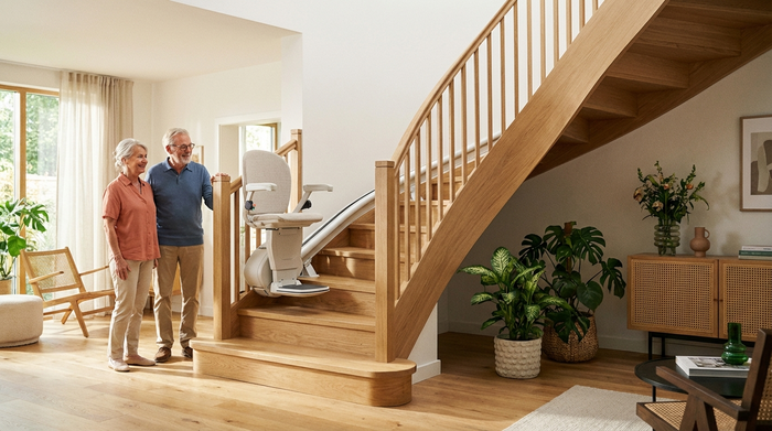 Ein moderner Treppenlift ist an einer eleganten Holztreppe in einem gepflegten Einfamilienhaus installiert. Die Szene ist hell und einladend, fokussiert auf die sichere Mobilität im eigenen Zuhause.