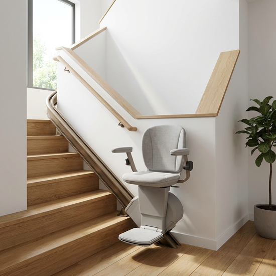 Ein moderner, bequemer Treppenlift in einem gepflegten, hellen Treppenhaus eines Einfamilienhauses. Der Sitz ist gepolstert, das Design ist unauffällig und elegant. Realistische Innenarchitektur, keine Personen im Bild.