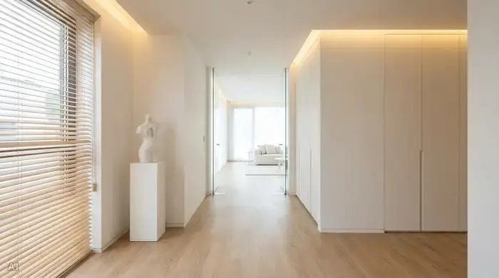 Ein schmaler, heller Flur in einem modernen Haus, komplett frei von Schuhen, Schirmständern und anderen Hindernissen, mit einem durchgehenden, hellen Vinylboden.
