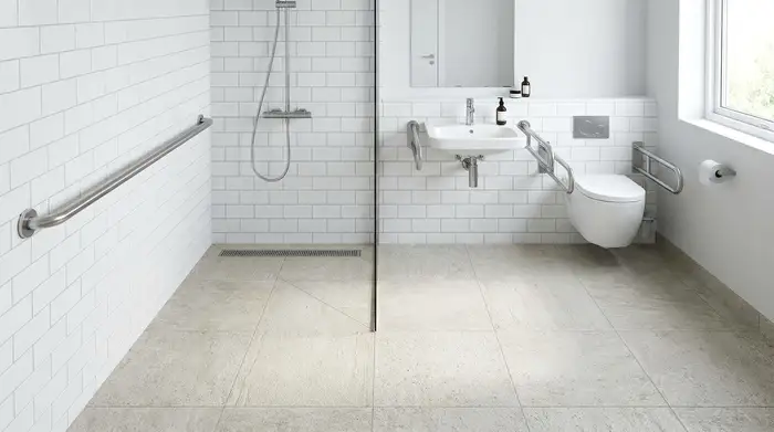 Eine moderne, barrierefreie Badezimmereinrichtung mit einem sicheren Haltegriff an der Wand und hellem, rutschfestem Boden. Sauber, aufgeräumt und sicher.