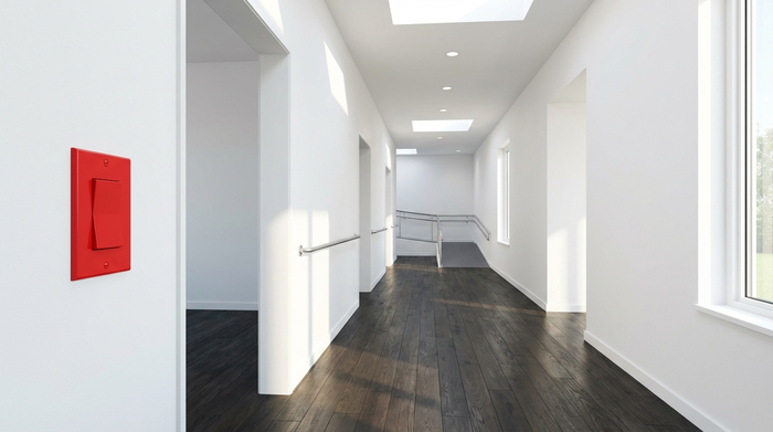Ein gut beleuchteter, barrierefreier Flur in einem modernen Zuhause. Helle Wände kontrastieren deutlich mit dunklen, rutschfesten Holzdielen. Ein roter Lichtschalter hebt sich stark von der weißen Wand ab. Keine losen Teppiche. Fotorealistisch, sauber, hell.